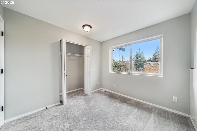 unfurnished bedroom featuring a closet, carpet, and baseboards