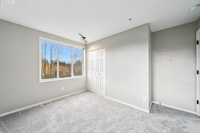 unfurnished room featuring carpet, visible vents, and baseboards