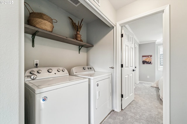 laundry room featuring visible vents, ornamental molding, washing machine and dryer, light carpet, and laundry area