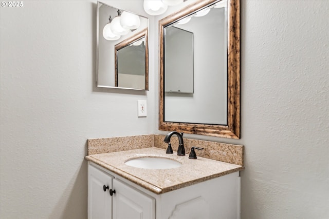 bathroom featuring a textured wall and vanity