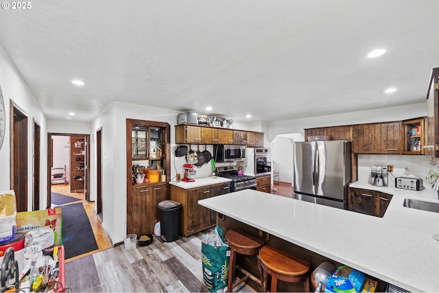 1366 Lakeshore Dr, Coos Bay, OR 97420 - kitchen featuring stainless steel appliances, light wood finished floors, light countertops, recessed lighting, and a peninsula