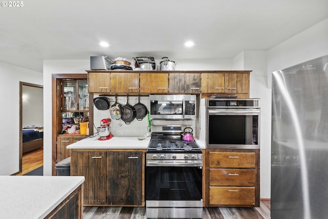 1366 Lakeshore Dr, Coos Bay, OR 97420 - kitchen featuring appliances with stainless steel finishes, light countertops, dark wood-type flooring, brown cabinets, and recessed lighting