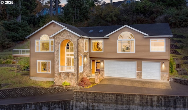 view of front facade featuring a garage, stone siding, and concrete driveway