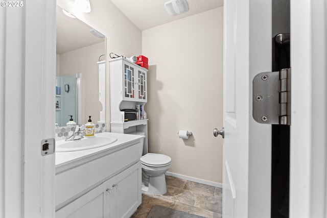 bathroom featuring vanity, a shower with shower door, and toilet