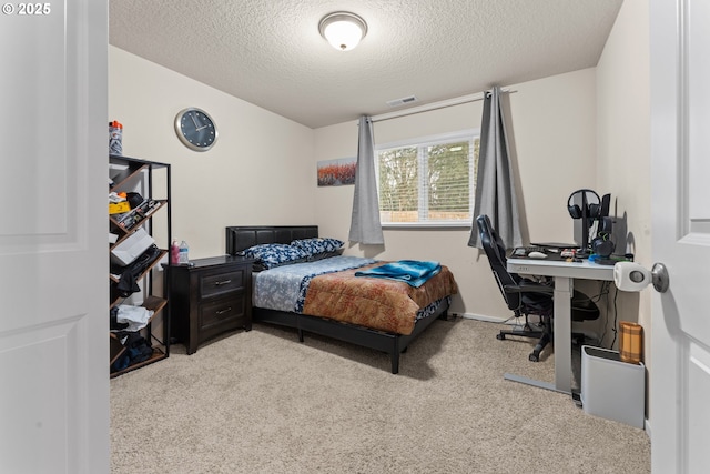 bedroom with a textured ceiling and light carpet