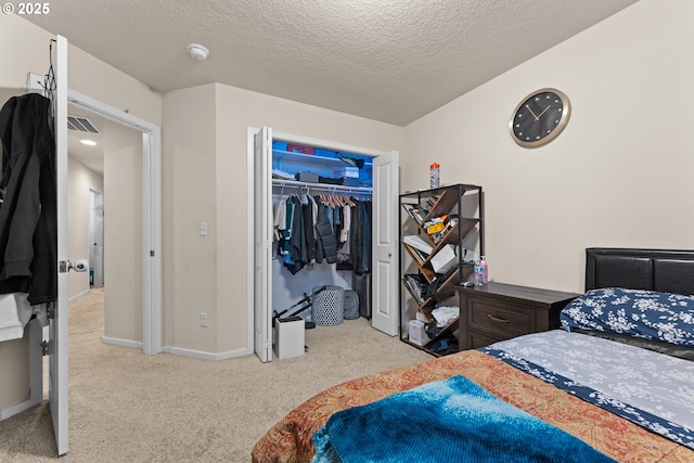 bedroom with a textured ceiling, a closet, and light carpet