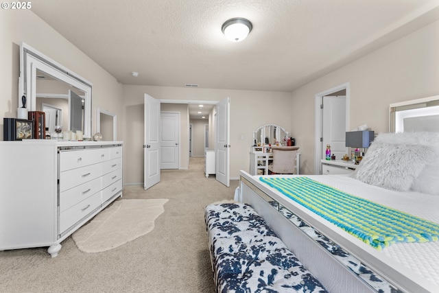 bedroom with a textured ceiling and light carpet