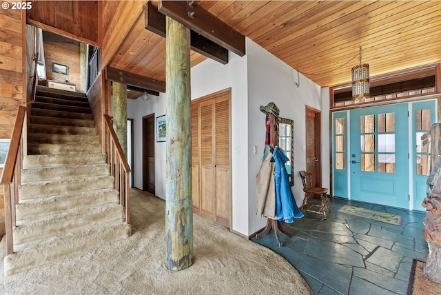 interior space featuring wooden ceiling, beamed ceiling, stairway, and stone tile floors