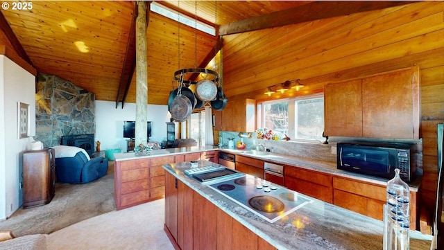 kitchen with black microwave, wooden ceiling, a stone fireplace, and beam ceiling