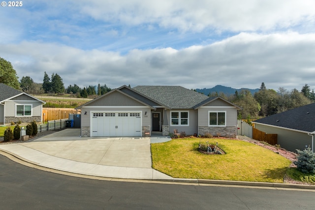 view of front of home with a garage, a mountain view, and a front yard