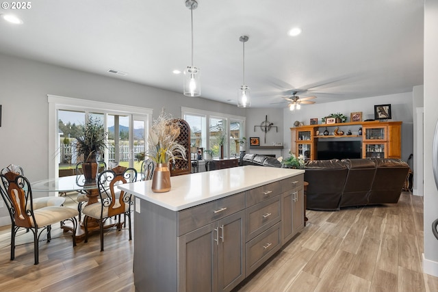 kitchen featuring a kitchen island, light hardwood / wood-style floors, pendant lighting, and ceiling fan