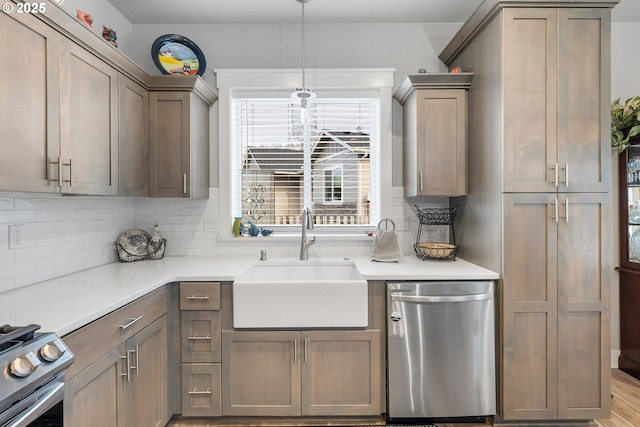 kitchen featuring sink, hanging light fixtures, appliances with stainless steel finishes, and decorative backsplash