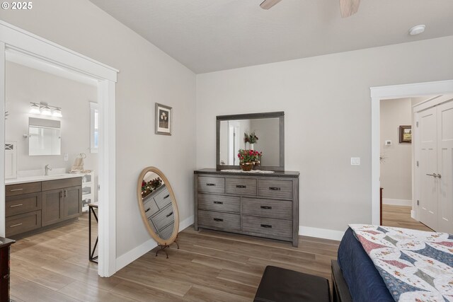 bedroom with ceiling fan, sink, and ensuite bath