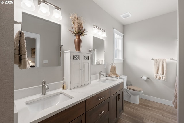 bathroom featuring wood-type flooring, toilet, and vanity