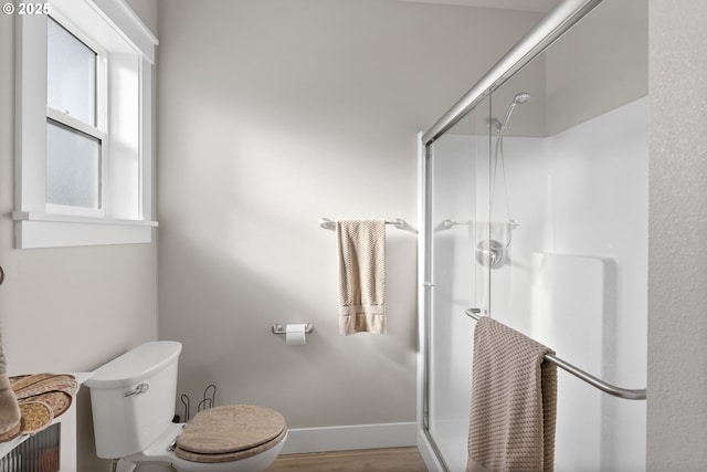 bathroom with hardwood / wood-style floors, toilet, and an enclosed shower