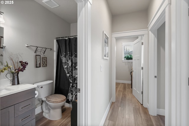 bathroom featuring hardwood / wood-style flooring, toilet, and vanity