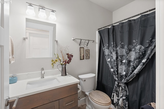 bathroom featuring toilet, vanity, and a shower with shower curtain