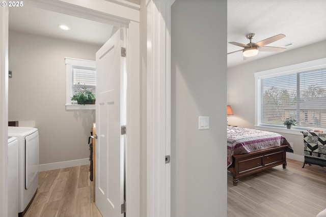 interior space with light hardwood / wood-style flooring, washer and clothes dryer, and ceiling fan