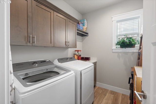 washroom with light hardwood / wood-style floors, cabinets, and independent washer and dryer