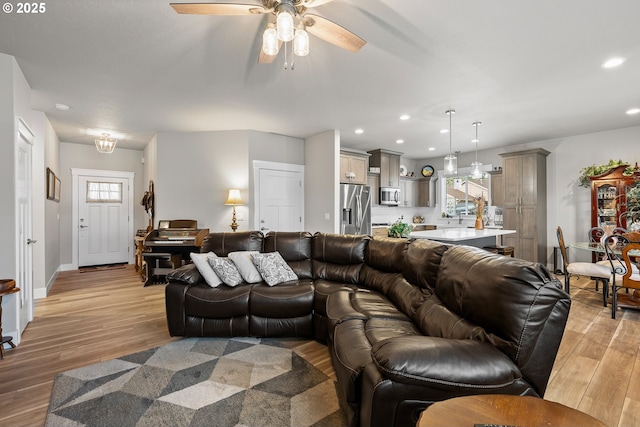 living room featuring light wood-type flooring and ceiling fan