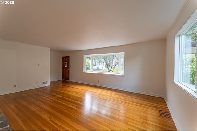 725 N 9th St, Coos Bay, OR 97420 - empty room with healthy amount of natural light, light wood-style flooring, and baseboards