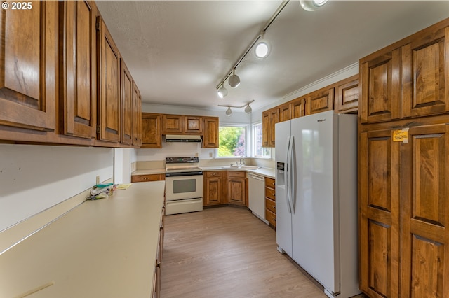 725 N 9th St, Coos Bay, OR 97420 - kitchen with white appliances, a sink, under cabinet range hood, brown cabinets, and light countertops