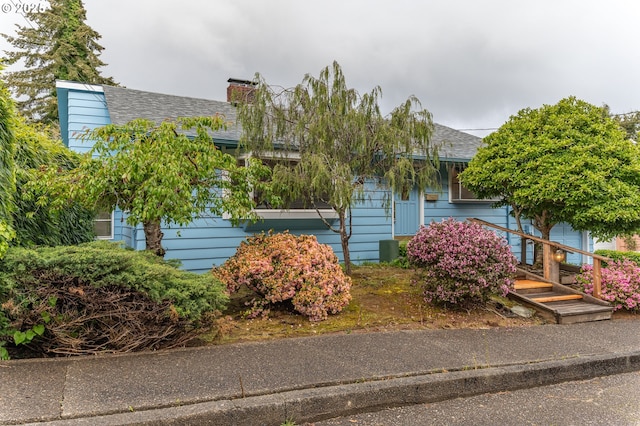 725 N 9th St, Coos Bay, OR 97420 - obstructed view of property featuring a shingled roof and a chimney