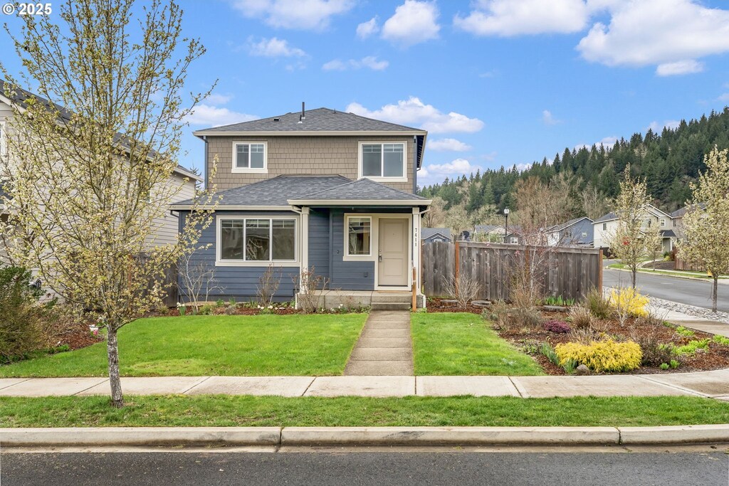 view of front of property with fence and a front lawn