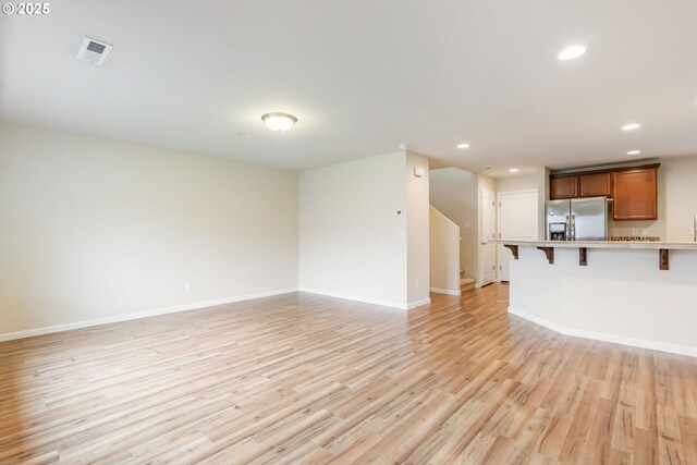 unfurnished living room with recessed lighting, baseboards, light wood finished floors, and visible vents