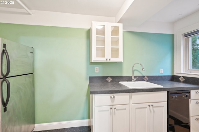 1529 SE Hawthorne Blvd Unit 2, Portland, OR 97214 - kitchen featuring freestanding refrigerator, black dishwasher, a sink, dark countertops, and white cabinetry