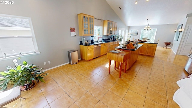 94342 Gauntlett St, Gold Beach, OR 97444 - kitchen featuring stainless steel dishwasher, a chandelier, light tile patterned flooring, dark countertops, and a center island with sink