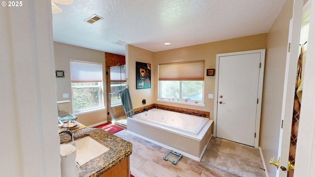 94342 Gauntlett St, Gold Beach, OR 97444 - bathroom featuring a tub with jets, vanity, a textured ceiling, and a shower