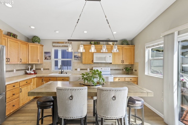 50990 Dike Rd Unit B3, Scappoose, OR 97056 - kitchen featuring white appliances, a sink, light wood finished floors, tasteful backsplash, and a kitchen island