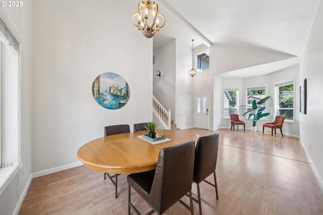 23295 SW Cascade Pl, Sherwood, OR 97140 - dining space featuring stairs, light wood-type flooring, a chandelier, baseboards, and high vaulted ceiling