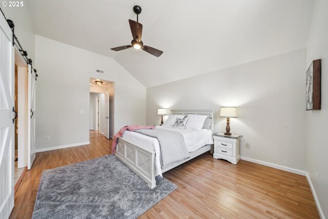 23295 SW Cascade Pl, Sherwood, OR 97140 - bedroom with a barn door, vaulted ceiling, light wood-style floors, baseboards, and ceiling fan