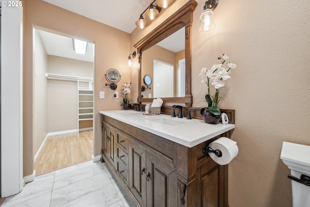 23295 SW Cascade Pl, Sherwood, OR 97140 - bathroom featuring marble finish floors, baseboards, double vanity, and a walk in closet