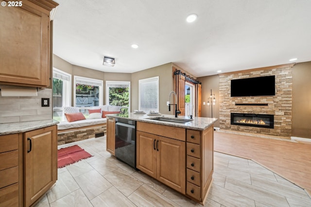 23295 SW Cascade Pl, Sherwood, OR 97140 - kitchen with open floor plan, a sink, dishwasher, a fireplace, and light stone counters