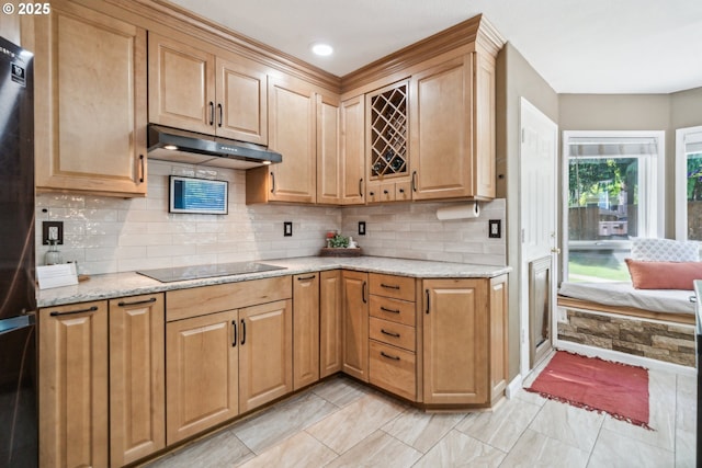 23295 SW Cascade Pl, Sherwood, OR 97140 - kitchen with under cabinet range hood, black electric stovetop, freestanding refrigerator, light stone counters, and decorative backsplash
