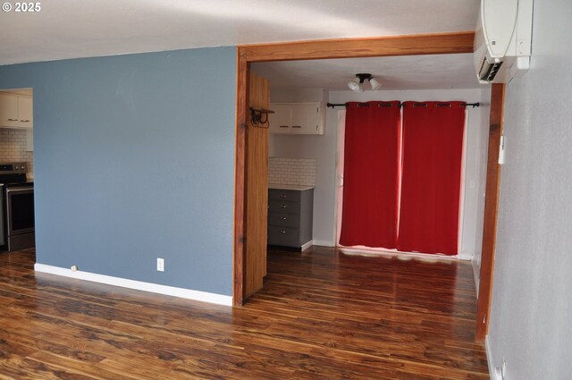 25821 Jeans Rd, Veneta, OR 97487 - unfurnished room with an AC wall unit, baseboards, and dark wood finished floors