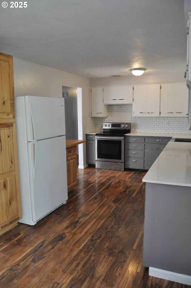 25821 Jeans Rd, Veneta, OR 97487 - kitchen with stainless steel range with electric cooktop, freestanding refrigerator, light countertops, decorative backsplash, and dark wood-style floors