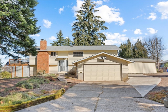 split foyer home featuring driveway, an attached garage, and a chimney