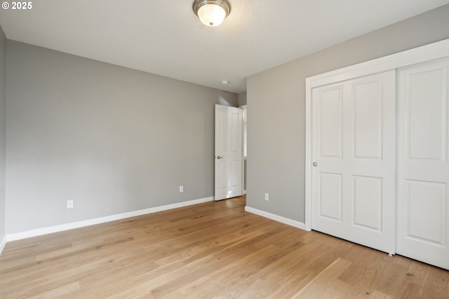 unfurnished bedroom with a closet and light hardwood / wood-style flooring