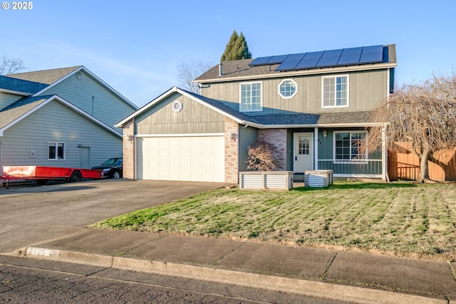 view of front of property with a garage, a front yard, solar panels, and a porch