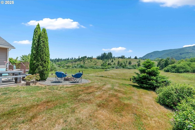 96863 Sitkum Ln, Myrtle Point, OR 97458 - view of green lawn featuring an outdoor fire pit, a mountain view, and a patio