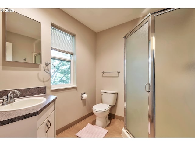 full bath featuring toilet, a shower stall, wood finished floors, and vanity