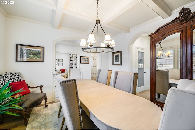 dining room with light wood-style floors, arched walkways, coffered ceiling, and an inviting chandelier