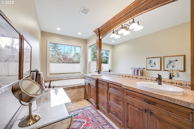 full bathroom with tile patterned floors, visible vents, a sink, and a bath