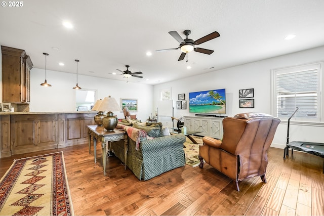 living area with light wood-style floors, recessed lighting, and a healthy amount of sunlight