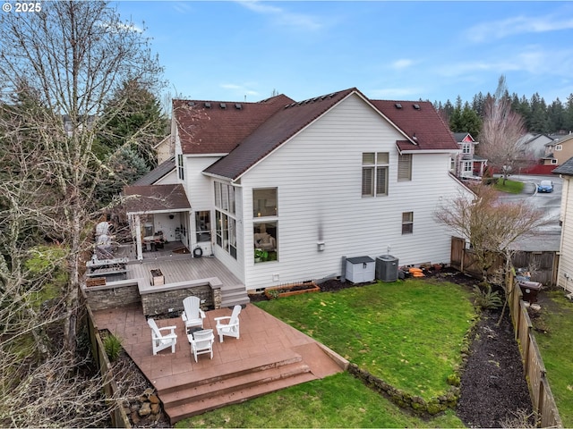 rear view of house featuring a fenced backyard, crawl space, a deck, a yard, and central AC