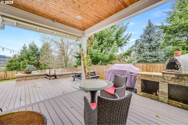 deck with a fenced backyard, outdoor dining area, and area for grilling